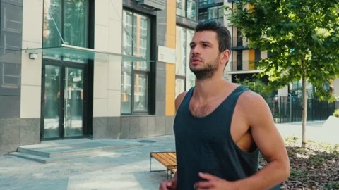 Young man exercising outside. Slow motion of strong powerful handsome guy doing Stock Footage 136409137