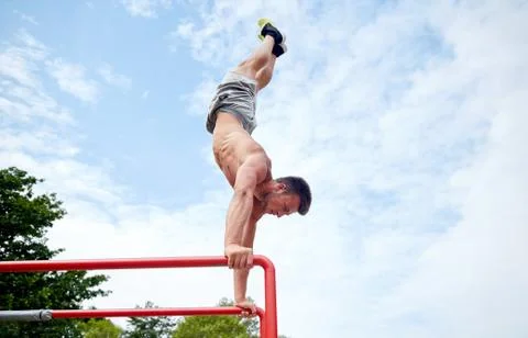 Young man exercising on parallel bars outdoors 写真素材