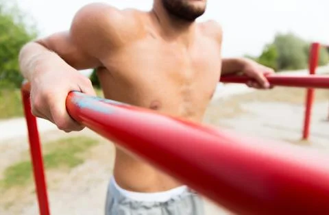 Young man exercising on parallel bars outdoors Stock-Fotos
