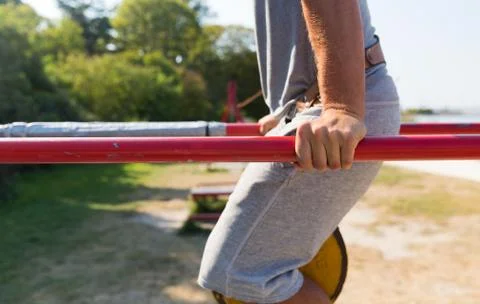Young man exercising on parallel bars outdoors Stock Photos