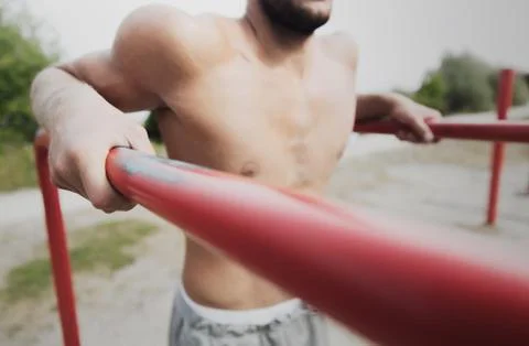 Young man exercising on parallel bars outdoors Stock-Fotos