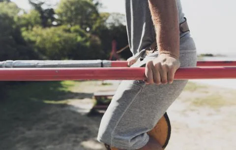 Young man exercising on parallel bars outdoors Stock Photos