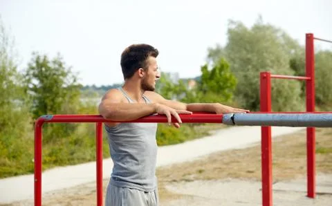 Young man exercising on parallel bars outdoors Stock-Fotos