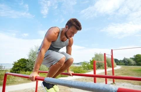 Young man exercising on parallel bars outdoors Stock-Fotos