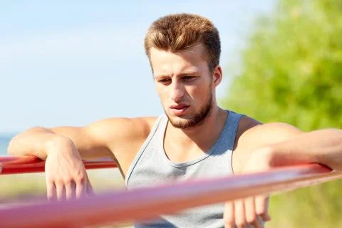 Young man exercising on parallel bars outdoors Stock-Fotos