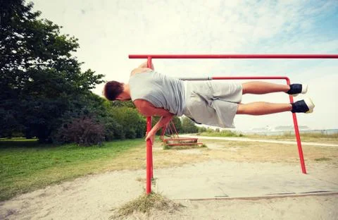 Young man exercising on parallel bars outdoors Stock-Fotos