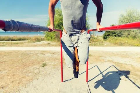 Young man exercising on parallel bars outdoors 스톡 사진