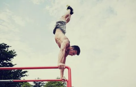 Young man exercising on parallel bars outdoors Foto stock