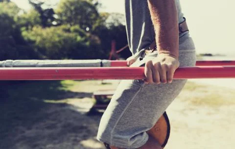 Young man exercising on parallel bars outdoors Stock Photos