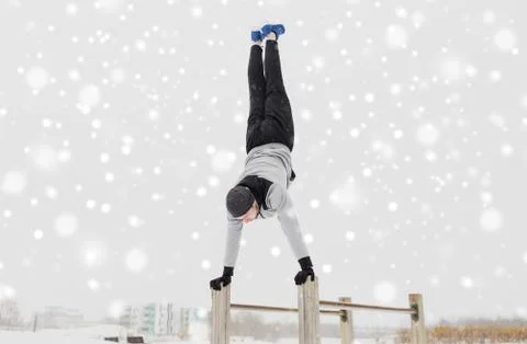 Young man exercising on parallel bars in winter 스톡 사진