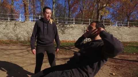Young Man Exercising in the park with personal trainer. Stock Footage 144814904
