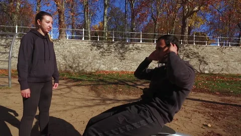 Young Man Exercising in park with Trainer Stock Footage 143466785