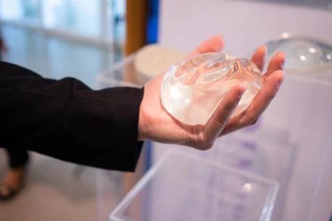A young man is experimenting with breast augmentation silicone for cosmetic s Stock Photos