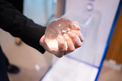 A young man is experimenting with breast augmentation silicone for cosmetic s Stock Photos
