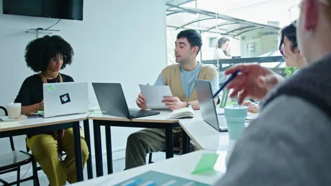 Young Man Explaining Financial Report to Business Team on Meeting Stock Footage 243945681