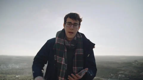 Young man explaining something with his phone in a beautiful landscape in P.. Stock Footage 240397430