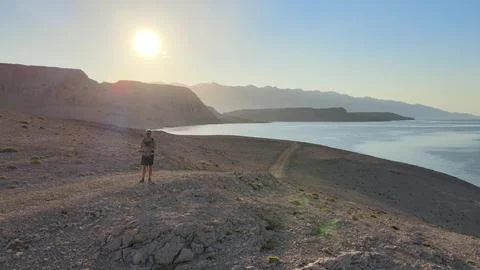 Young man explore remote area while hiking and using smart tablet Stock Photos