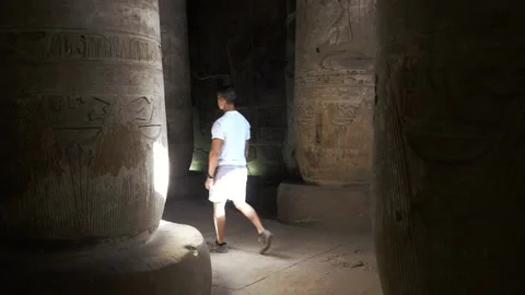 Young man explores ancient Egyptian temple Stock Footage 165529443