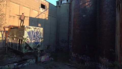 Young Man Explores Building Ruins Standing Arms Out on Engine Room Stock Footage 82353281