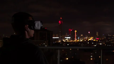 Young man exploring virtual reality at night Stock Footage 138720213