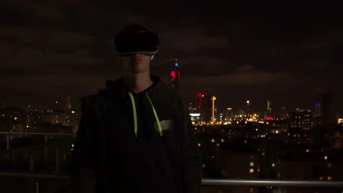 Young man exploring virtual reality at night Stock Footage 138720278