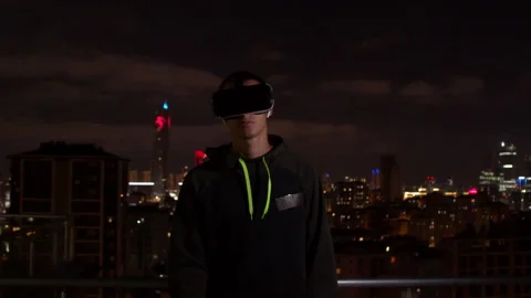 Young man exploring virtual reality at night Stock Footage 138720363
