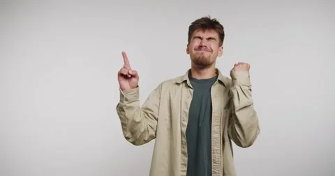 Young man expresses joy and excitement while celebrating a successful momen.. Видео 326788374
