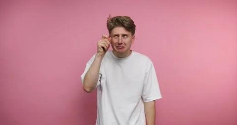 Young man expresses various emotions in front of a pink background during a.. Stock Footage 317327880