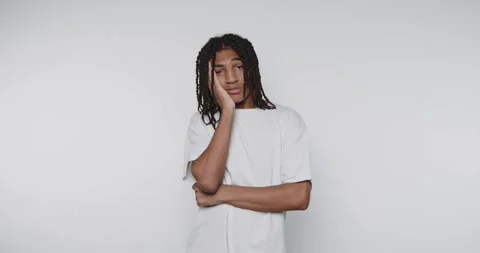 Young man expressing contemplation while posing in a minimalistic studio en.. Stock Footage 313951163