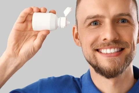 Young man with eye drops on light background, closeup Stock Photos