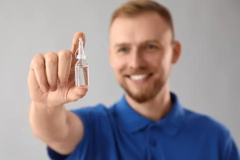 Young man with eye drops on light background, closeup Stock Photos