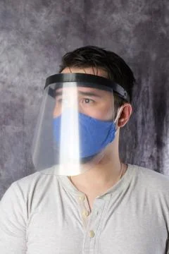 Young man with face mask and plastic face shield Stock Photos
