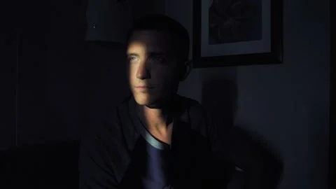 Young man face with sunbeam on eye in dark black room Stock-Footage 137352105