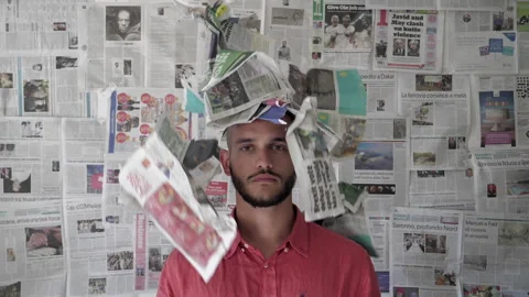 Young man with falling newspapers on his head Stock Footage 164148201