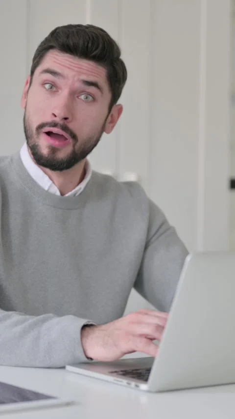Young Man Feeling Shocked while using Laptop in Office, Vertical Video Stock Footage 339582089