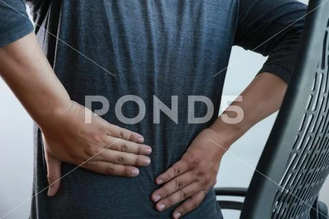 Young man Feeling suffering Lower back pain Pain relief concept Stock Photos