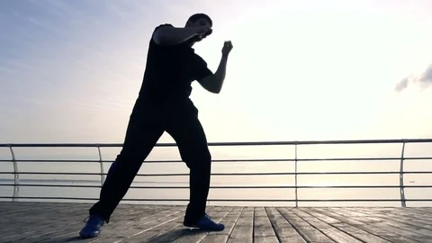 Young man fight training against sunrise in slow motion Video stock 77832150