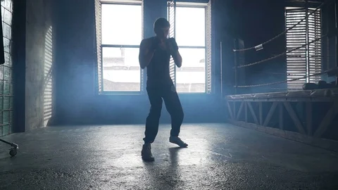 Young man fights the shadow training near boxing ring in industrial gym Stock Footage 91586072