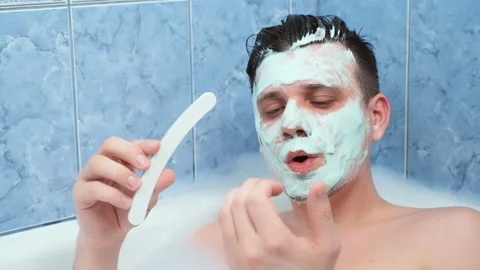 Young man is filing his nails sitting in bathroom with mask on face. Stock Footage 158167761