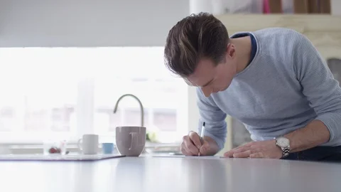 Young man filling in a form on a table Stock Footage 88195571