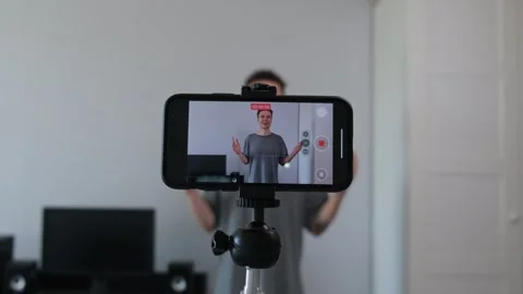 Young man filming self-development vlog in simple home interior. Authentic setup Stock Footage 311571382