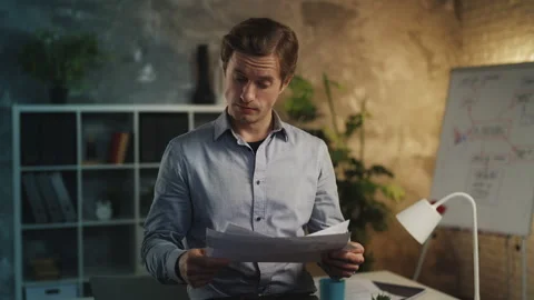 Young man financial analyst checking business reports in office, doing paperwork Stock Footage 340960983