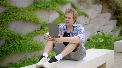 A Young Man Finds Joy in Both Engaging with Modern Technology and Being in Stock Footage 282211008