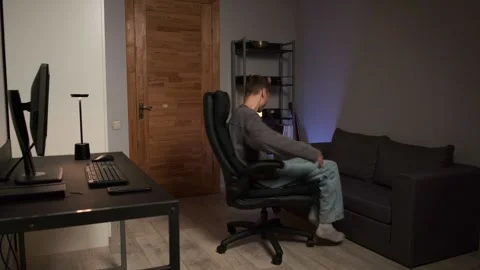 Young man finishing computer work having fun spinning on office chair home Stock Footage 315413713