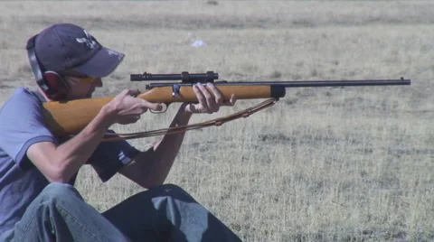 Young man fires small caliber rifle at target Stock-Footage 954186