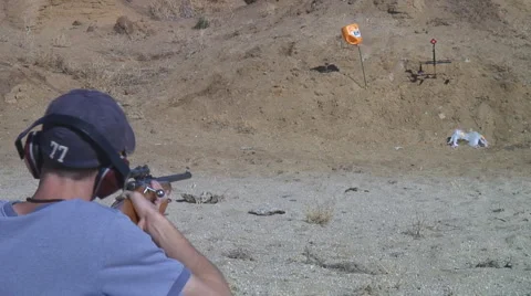 Young man fires small caliber rifle at target Stock Footage 954187