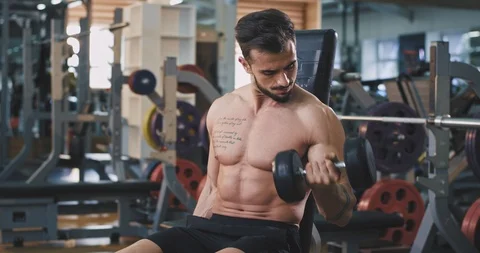 Young man with a fit body practicing sport on the gym working in his biceps Stock Footage 114759551