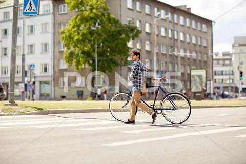 Young man with fixed gear bicycle on crosswalk Stock Photos