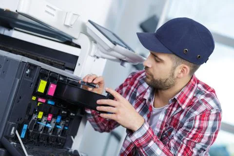 A young man fixing printer Stock Photos