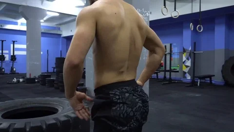 Young man flipping tyre while exercising. Stock Footage 87087262